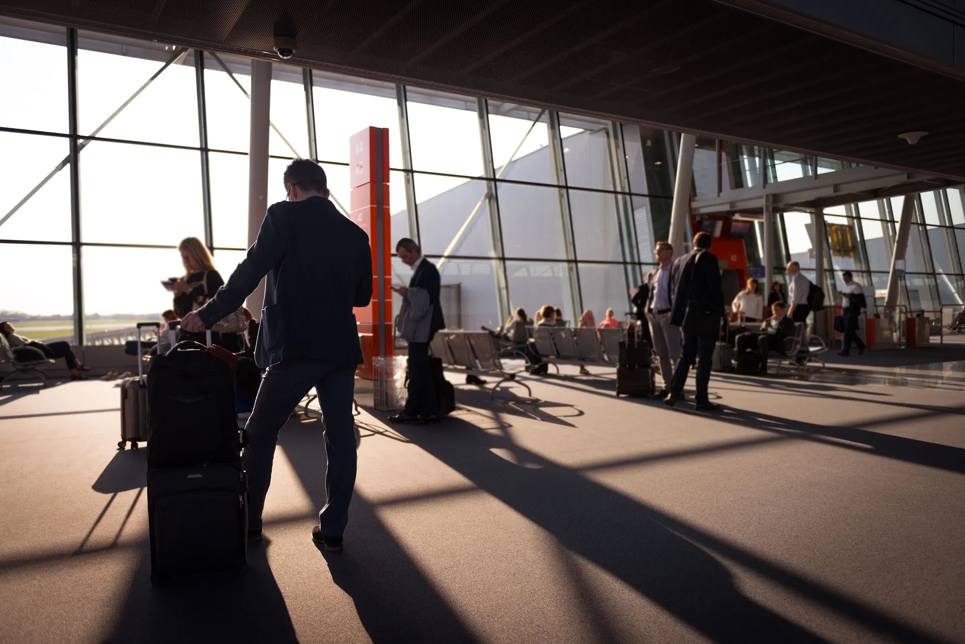 Voyageurs avec leurs valises dans un hall d'aéroport