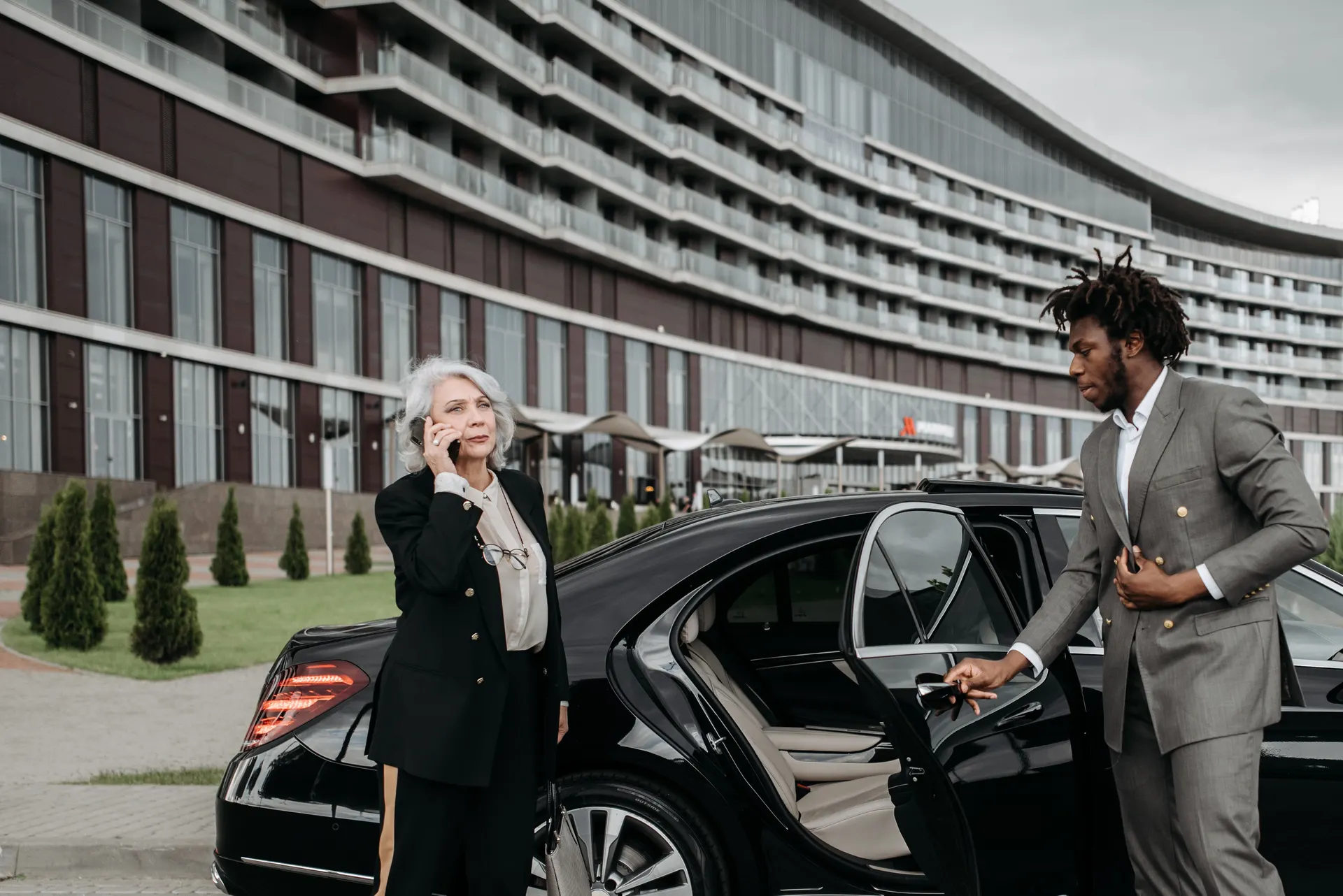 Chauffeur privé ouvrant la porte d'un véhicule noir